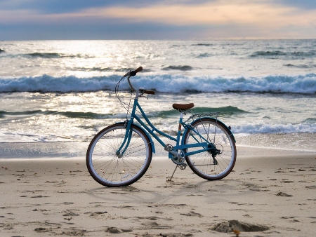 Bicicleta en la playa frente a las olas del mar
