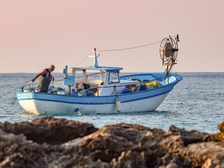 Pescar en Ibiza: Pescador en su barco frente a la costa