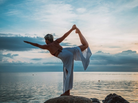 Practicando yoga junto al mar