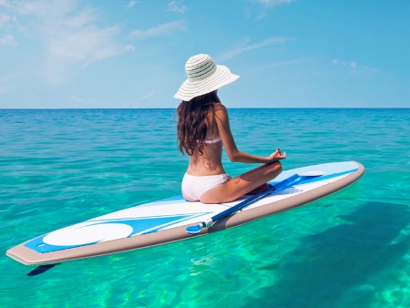 Yoga y meditación sobre una plancha en el mar