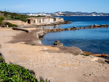 Casetas de pescadores en el muelle salinero con Ibiza al fondo